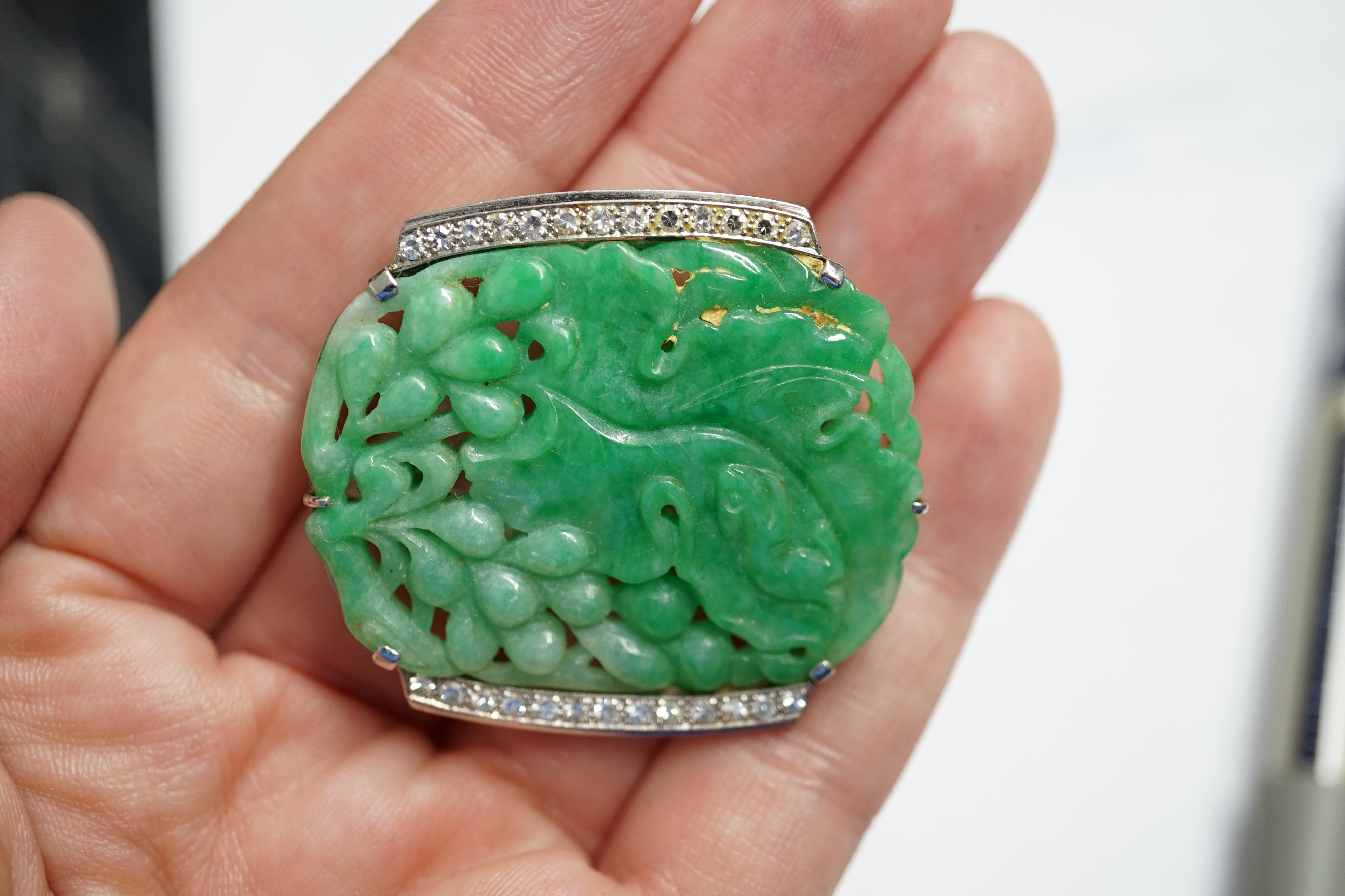 A Chinese white gold and diamond cluster set carved jade leaf and fruit brooch